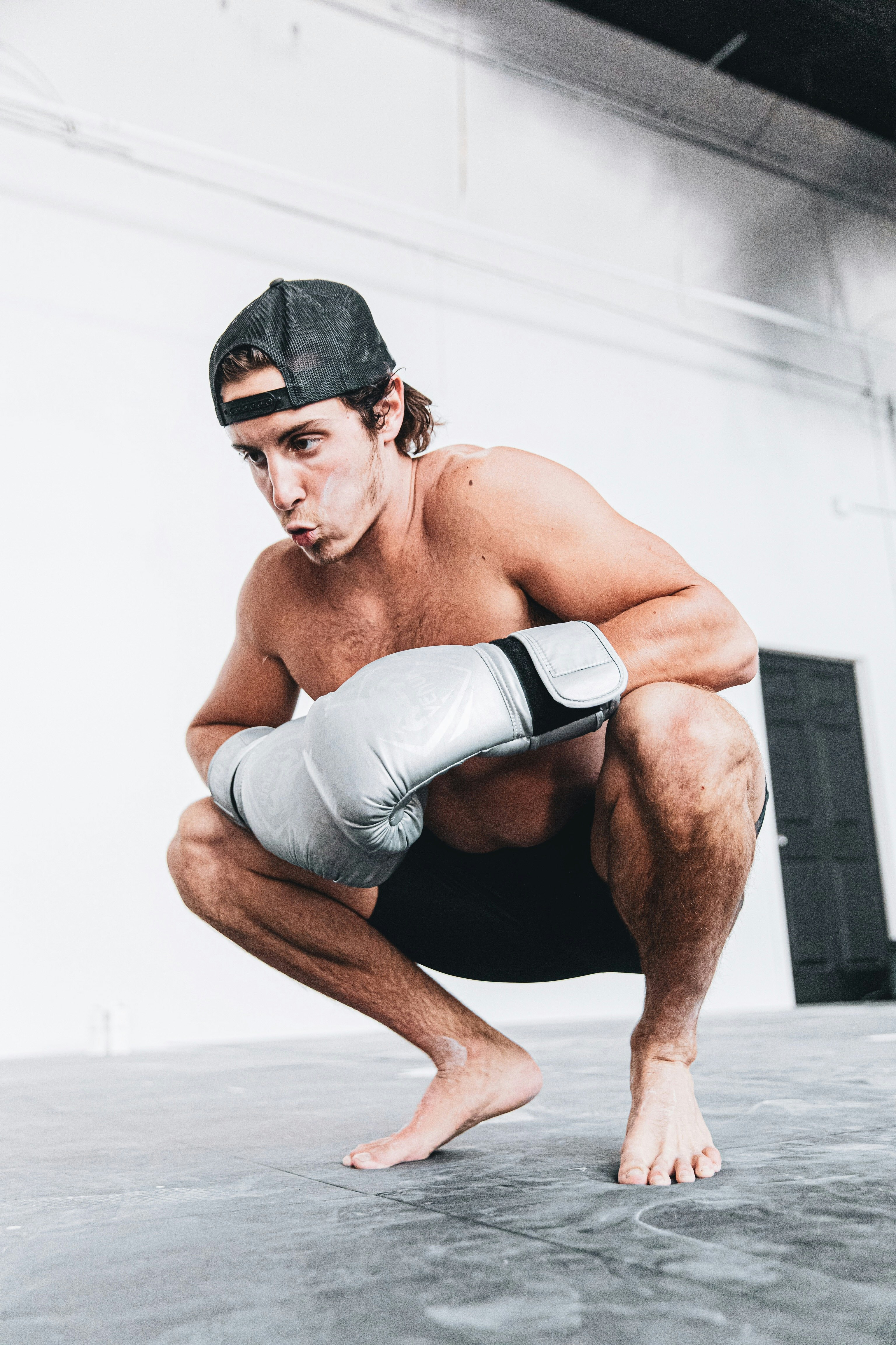 topless man in gray shorts sitting on floor